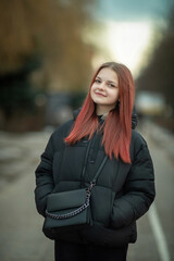 Fototapeta premium Portrait of a young beautiful long-haired girl on a spring city street.