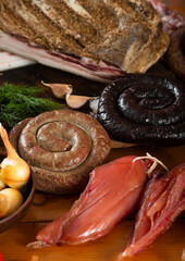 Assorted meat village homemade delicacies among vegetables and herbs