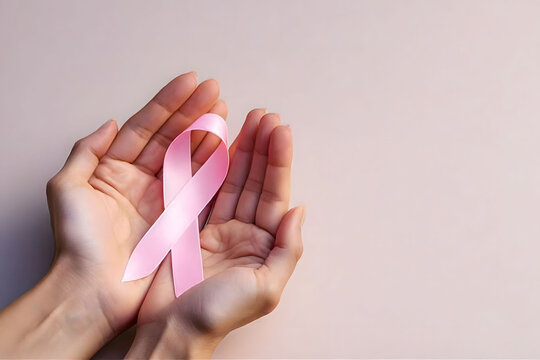 Hands gently holding a pink ribbon, symbolizing support and awareness for breast cancer