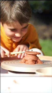 Child trimming clay on potter's wheel