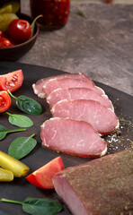 Assorted meat village homemade delicacies among vegetables and herbs