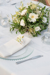Wedding table decoration with fresh colorful flowers, plates and candles