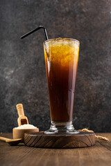 Traditional sweet iced tea with sugar and ice in tall glasses on wood table
