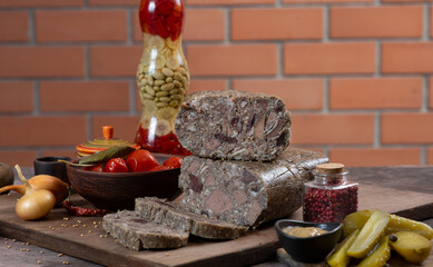 Meat pate with pieces of meat among pickles, vegetables and herbs. Saltison.
