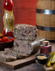 Meat pate with pieces of meat among pickles, vegetables and herbs. Saltison.