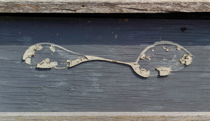 weathered wood spoon on wall of shuttered restaurant