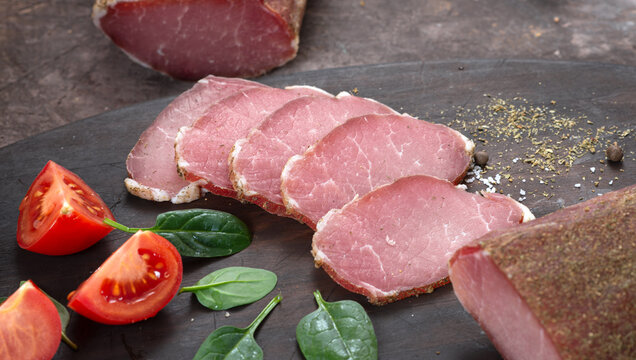 Meat dried pork ham cut into strips among vegetables and herbs