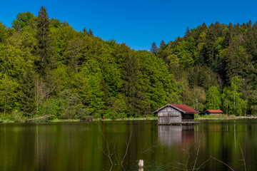 Fototapeta na wymiar Holzhütte und Wasserwacht im Hackensee Holzkirchen mitten im Wasser