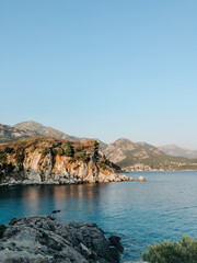 Fototapeta na wymiar Top view Montenegro Sutomore stones beach blue turquoise Adriatic sea water mountains on sunset.