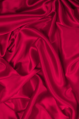 Rich and luxury red silk fabric texture background.