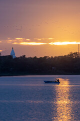puesta de sol con pescador y templo