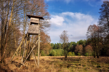 Photo of an elevated deer hunting blind by the woods.