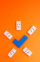 Check mark surrounded by happy faces, wooden figures that are part of a puzzle