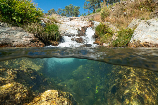Cascade in a stream seen from water surface, split view half over and under water, natural scene, Spain, Galicia, Pontevedra province