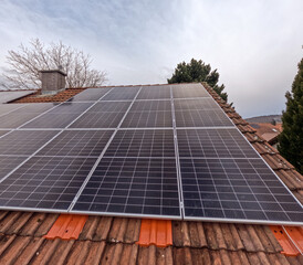 Solar panels on a roof with red tiles