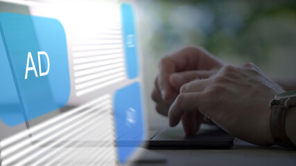 person working on a laptop computer with a fictional website with Ads hovering as a hologram over the keyboard, advertising, marketing, online, digital, business, augmented reality, remote work