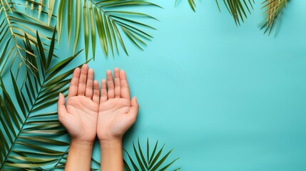 hands and green palm leaves on aqua background with copy space - obrazy, fototapety, plakaty
