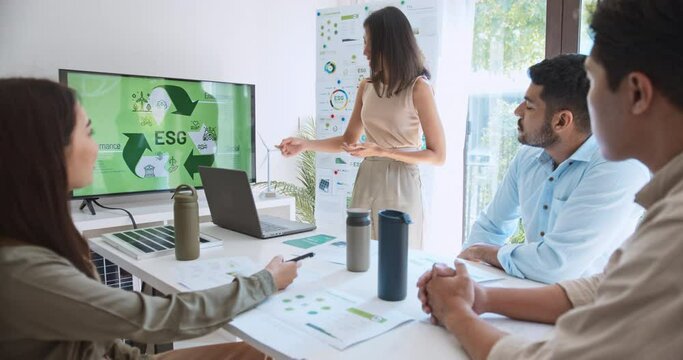 Asian woman lead young group of multiethnic businesspeople in team meeting, using laptop computer for ESG topic presentation on monitor. Sustainable business practice, people work at home concept