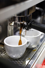 professional coffee maker preparing espresso in cup