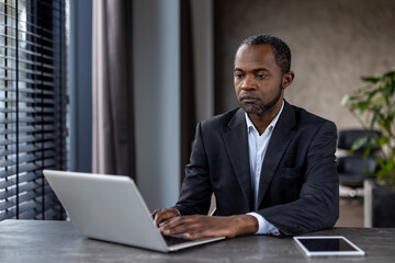 Professional african american businessman working on laptop in office environment