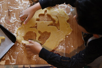 Rolling pin and dough. Kid making fancy biscuits halloween cookie cutter pastry dough on the messy...