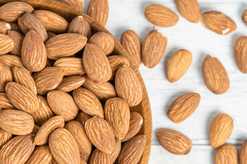 Fresh natural healthy almonds nuts on a wooden plate.