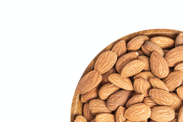 Fresh natural healthy almonds nuts on a wooden plate.