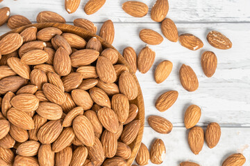 Fresh natural healthy almonds nuts on a wooden plate.