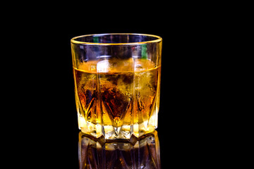 Glass of whiskey isolated on the black background