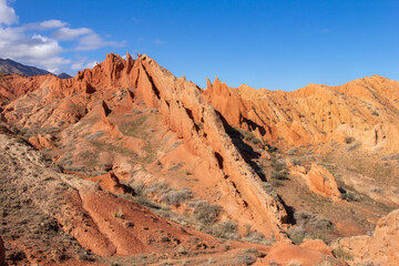 Fototapeta na wymiar landscape of Skazka canyon on Issyk-Kul lake. Rocks Fairy Tale famous destination in Kyrgyzstan. Mountain like great wall of china and Rainbow Mountains of Danxia or Antelope crevice USA. Central Asia