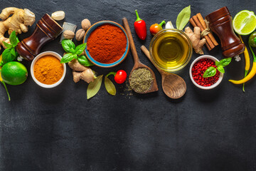 Colorful food cooking ingredients background with various herbs and spices on on a dark stone...