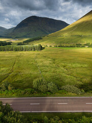 Aerial view of the A82 road as it passes through Bridge of Orchy with the mountains. Highlands Scotland