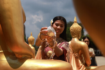 Asia women in Thai traditional dress holding lotus flower and silver Bowl to pray respect and...