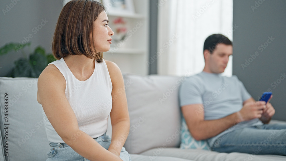 Wall mural beautiful couple sitting on sofa silent with problem using smartphone at home