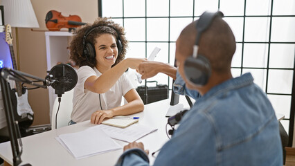 Obraz premium Two smiling radio reporters bumping fists in agreement during live interview at the radio studio