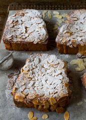 Sweet bread cut into slices and spread with a thin fruit glaze and topped with an almond spread. Vertical photo