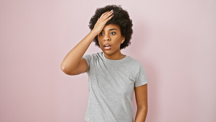 Surprised african american woman with curly hair standing against a pink wall, expressing shock or memory lapse - obrazy, fototapety, plakaty
