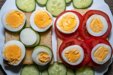 Toast bread with eggs, tomatoes and cucumber slices in a plate
