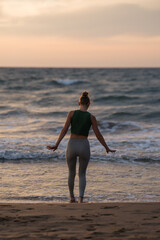 Fototapeta na wymiar Woman Meditating by the Sea at Sunset