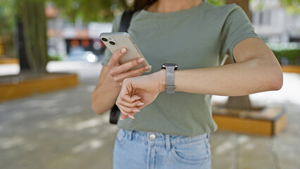 Outdoor shot, woman's hands caught texting time countdown on smartphone watch at park amidst city...
