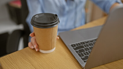 Elegant business womanâ€™s hands working online with laptop, enjoying morning espresso coffee at office table