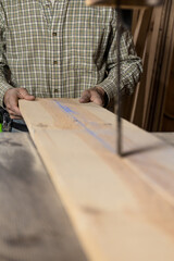 Vertical photo detailed work of carpenter man adult at bandsaw. Copy space. Business concept.