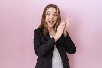 Young caucasian business woman wearing black jacket clapping and applauding happy and joyful, smiling proud hands together