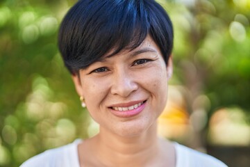 Middle age chinese woman smiling confident standing at park