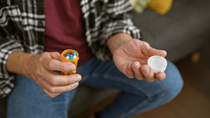 Middle-aged man holding medication at home, depicting health and domestic life.