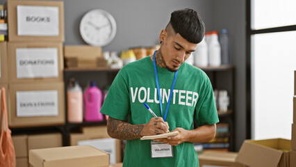 Dedicated young latin man, a volunteer worker lending his support at the heart of a charity center,...