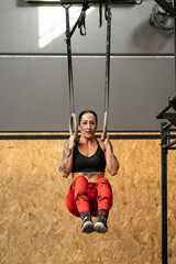 Woman training with olympic rings in a cross training center