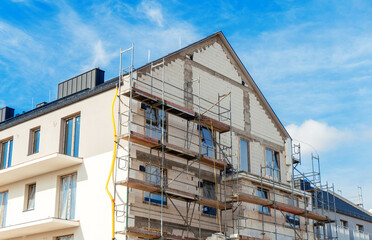 Construction of a house, scaffolding is installed outside the structure of the house to carry...