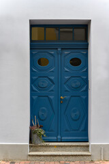 Blau gestrichene Haustür mit ornamentalen Schnitzereien in der Altstadt von Güstrow - Inschriften...