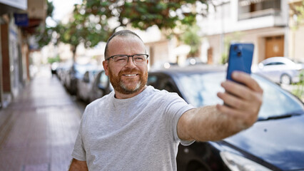 Confident caucasian man, all smiles while making a fun-filled selfie with his smartphone on a...